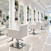 Row of illuminated LED mirrors at individual styling stations in a modern white hair salon.